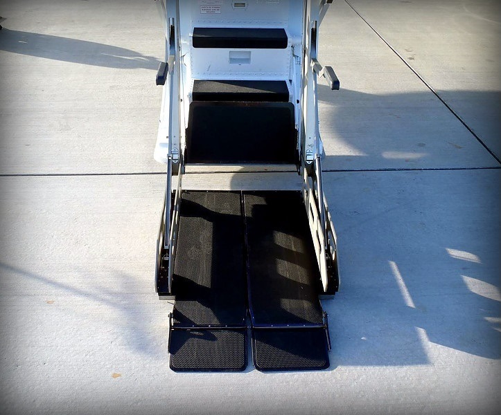 Wheelchair lift ramp lowered to the tarmac beside a private jet in Philadelphia, Pennsylvania